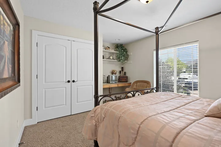 Carpeted room featuring white bi-fold closet doors with black hardware