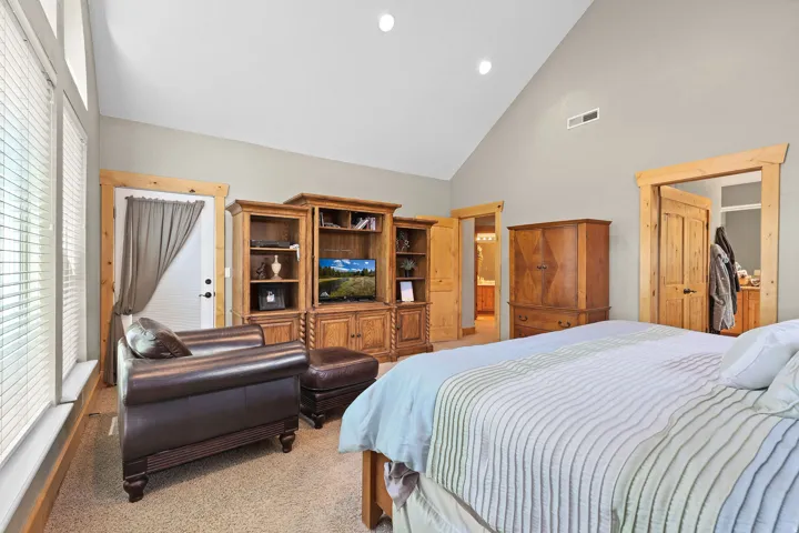 Vaulted ceiling with recessed lighting, light gray wall paint, and natural wood trim throughout