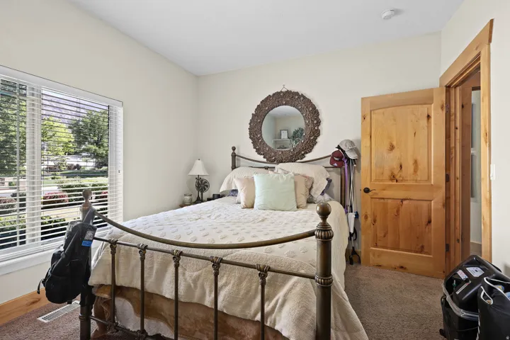 Carpeted room with a large window featuring horizontal blinds