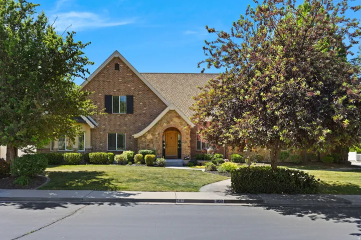 Brick and stone exterior featuring an arched entryway with a wooden front door