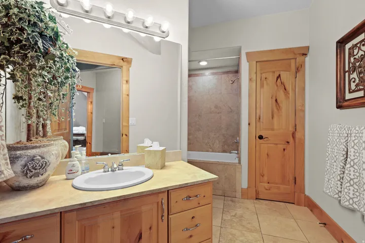 Bathroom featuring a vanity with a drop-in sink, wood cabinetry, and a light-toned countertop