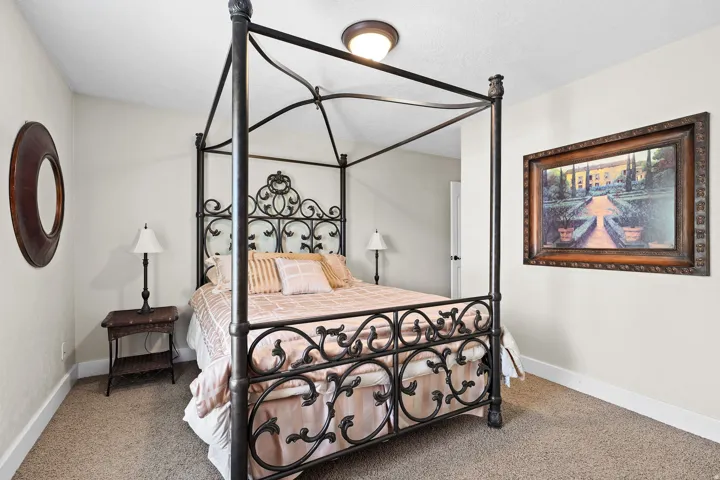 Carpeted bedroom with neutral wall paint and white baseboards
