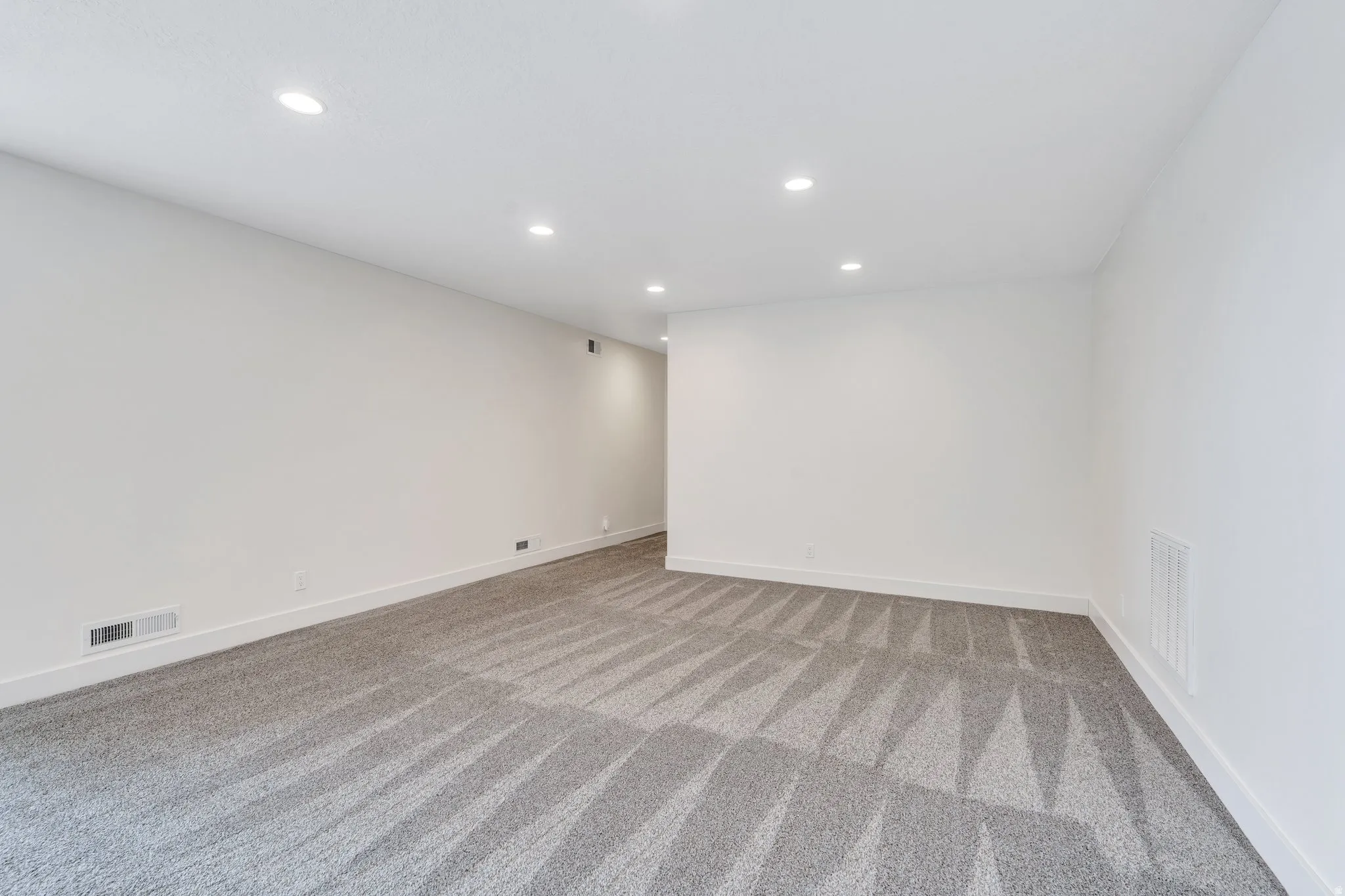 Spare room featuring recessed lighting and light colored carpet