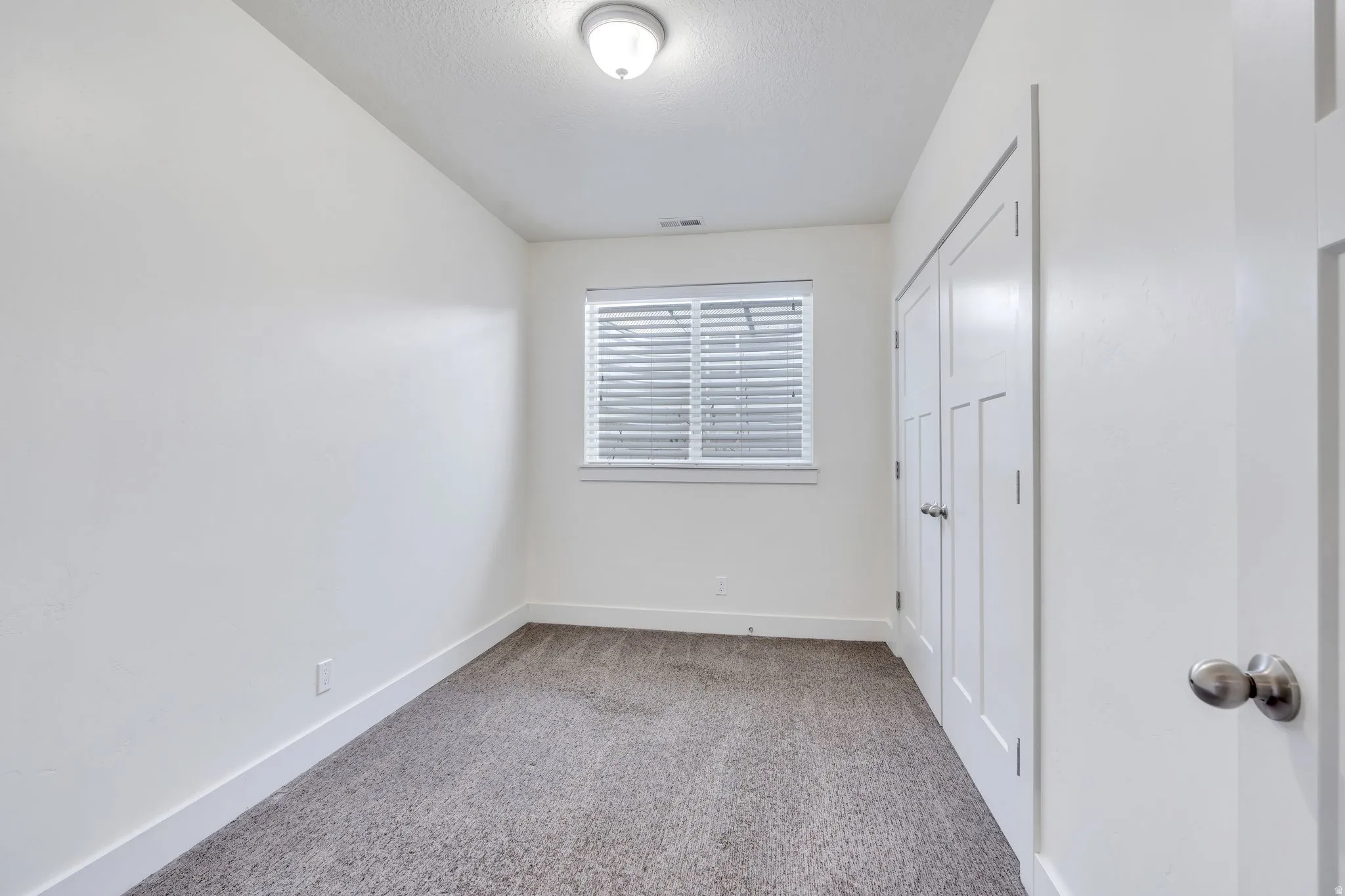 Unfurnished bedroom featuring light carpet and a closet