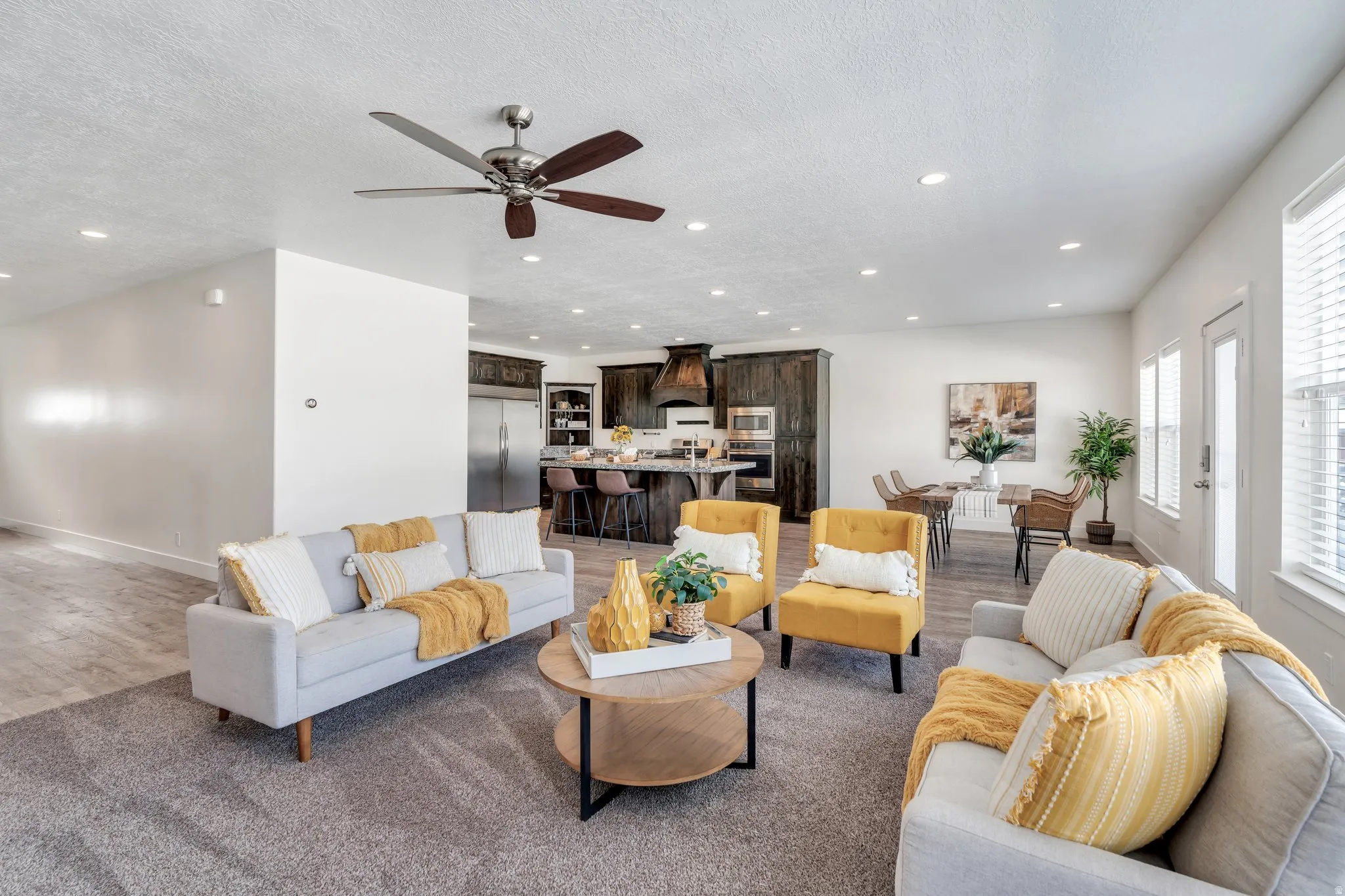 Living area with light wood-style flooring, recessed lighting, a textured ceiling, and ceiling fan