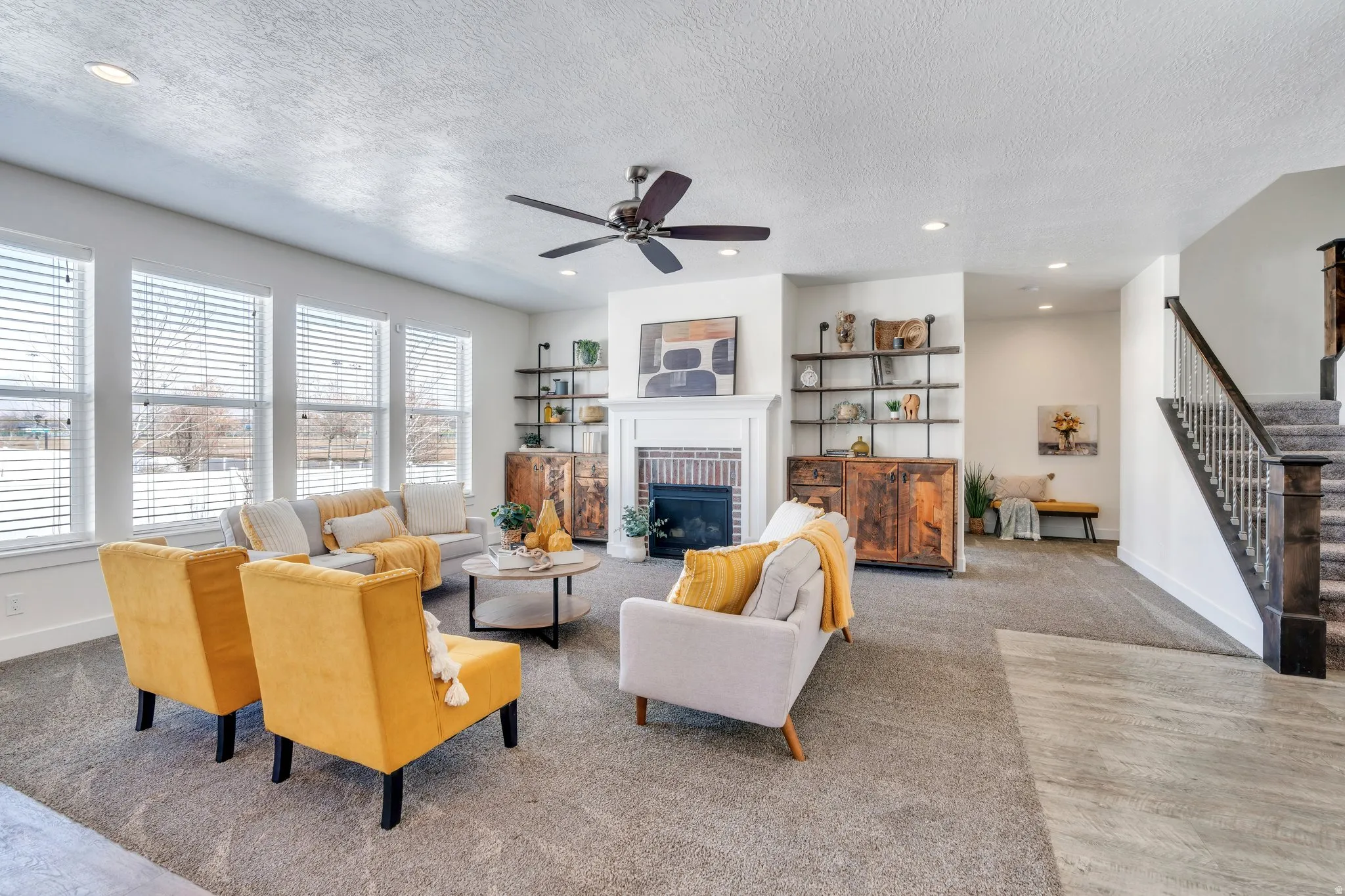 Living area featuring carpet floors, recessed lighting, a fireplace, a ceiling fan, and a textured ceiling