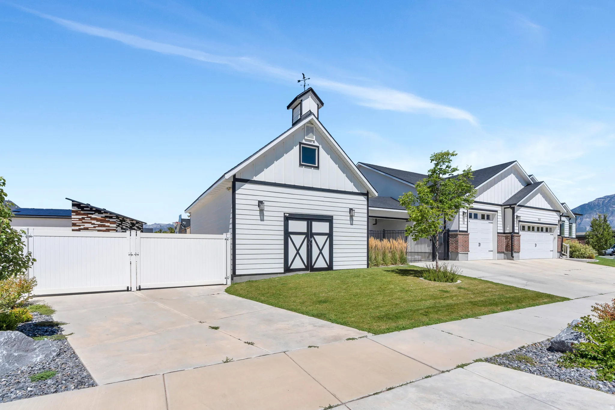 View of front of property with a gate, concrete driveway, and board and batten siding