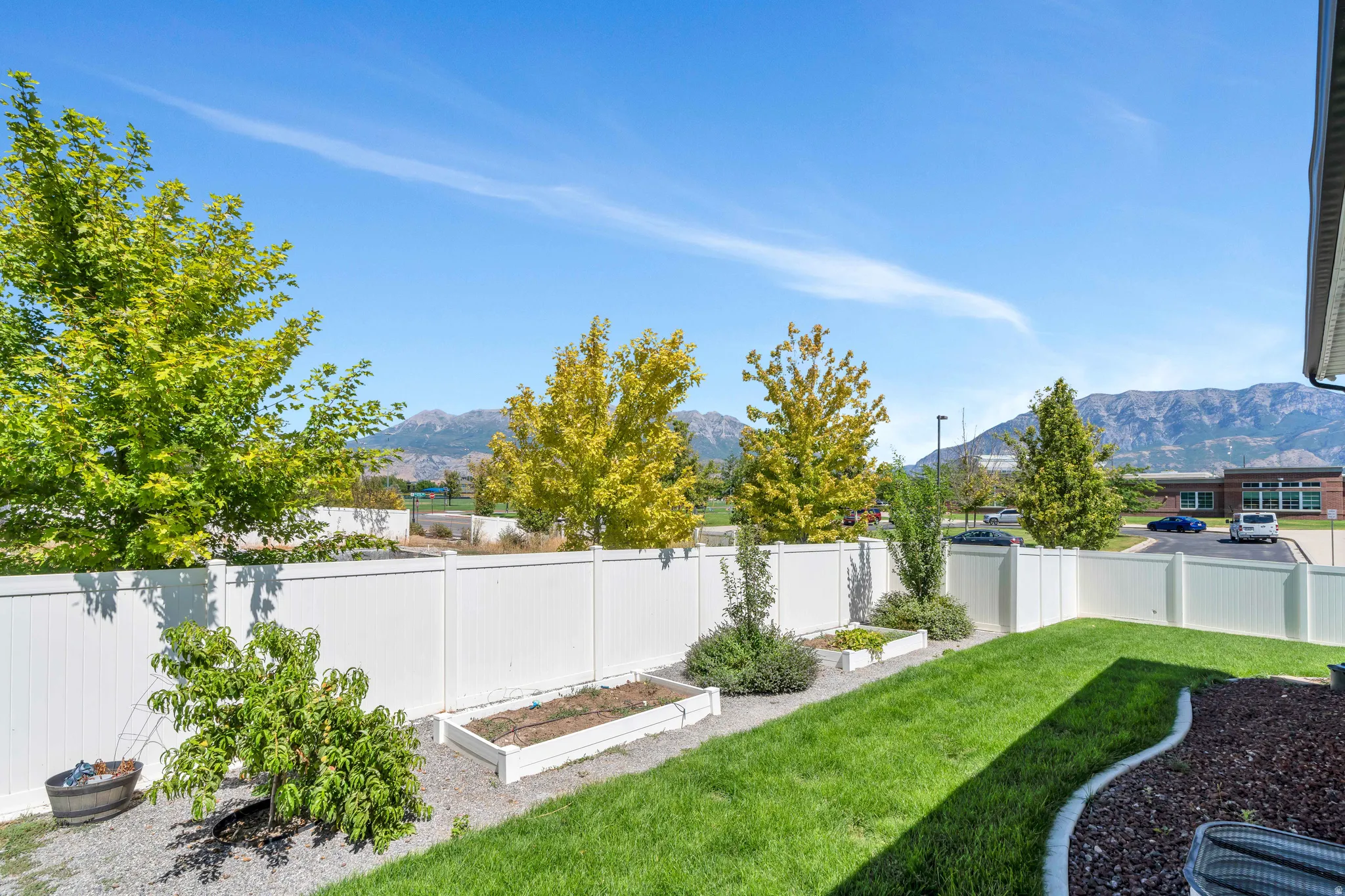 Fenced backyard featuring a vegetable garden and a mountain view