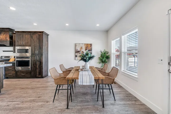 Dining room with light wood-style flooring and recessed lighting
