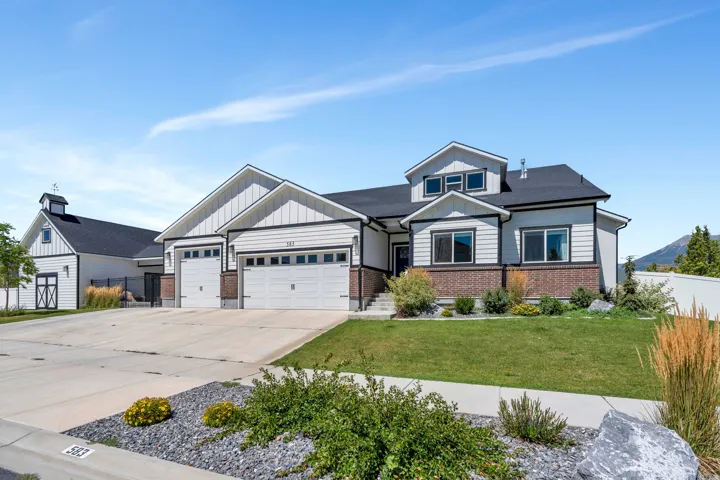 View of front facade featuring concrete driveway, an attached garage, and brick siding
