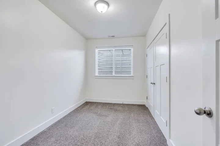 Unfurnished bedroom featuring light carpet and a closet