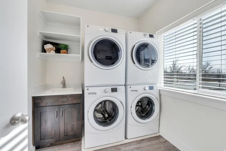 Laundry area with a sink and stacked washer and dryer