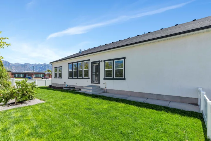 Rear view of property featuring a mountain view and a shingled roof