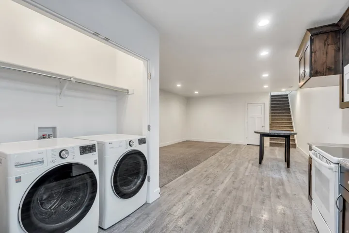 Laundry room featuring recessed lighting, light wood finished floors, and washing machine and dryer