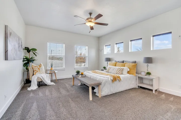Carpeted bedroom with baseboards and a ceiling fan
