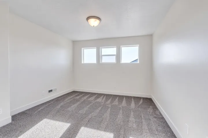 Spare room with baseboards and light colored carpet