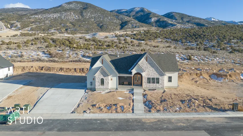 View of front of house with a mountain view, stone siding, and concrete driveway