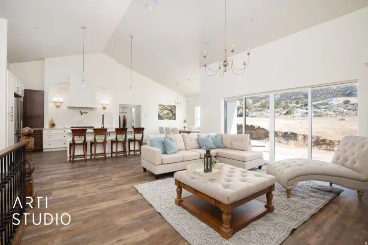 Living area featuring a high ceiling, dark wood-type flooring, and suspended lighting