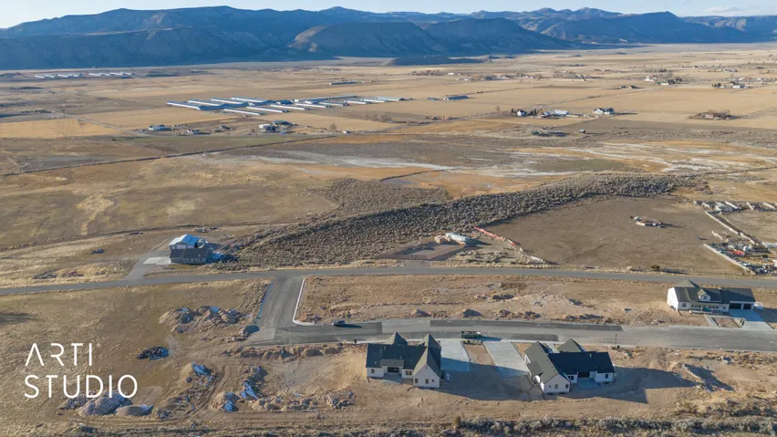 Aerial view of property and surrounding area featuring a mountainous background and rural landscape