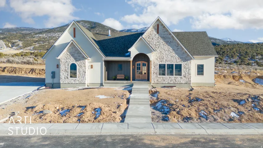 View of front facade featuring stone siding, a mountain view, and a porch