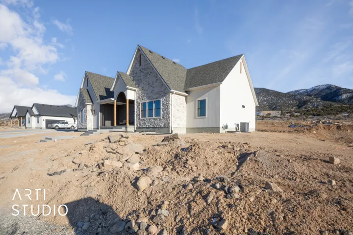 View of front facade with stone siding and roof with shingles