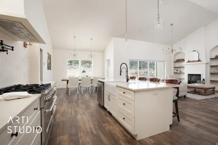Kitchen with a chandelier, a breakfast bar area, stainless steel appliances, light stone counters, and lofted ceiling