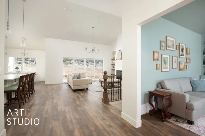 Living area with a chandelier, dark wood-type flooring, a fireplace, and vaulted ceiling