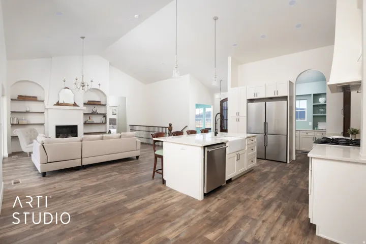 Kitchen with white cabinets, suspended lighting, a kitchen breakfast bar, open floor plan, and light stone counters