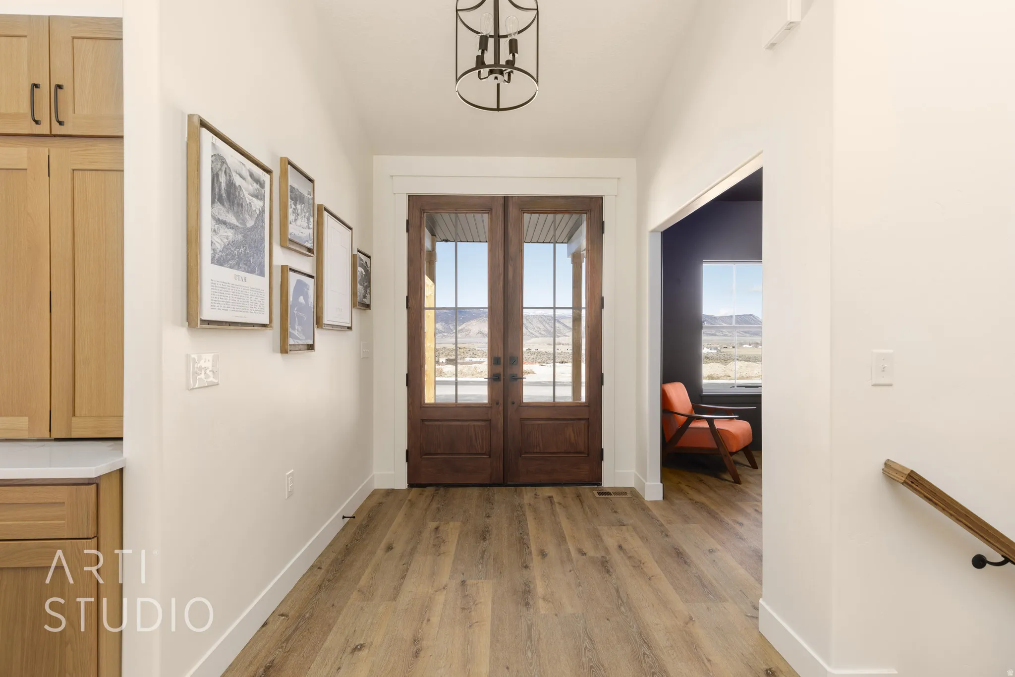 Foyer entrance featuring light wood-style floors, lofted ceiling, and french doors