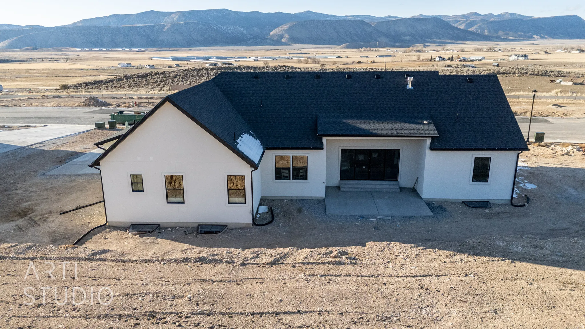 View of front facade featuring a mountain view, stucco siding, a desert view, and roof with shingles