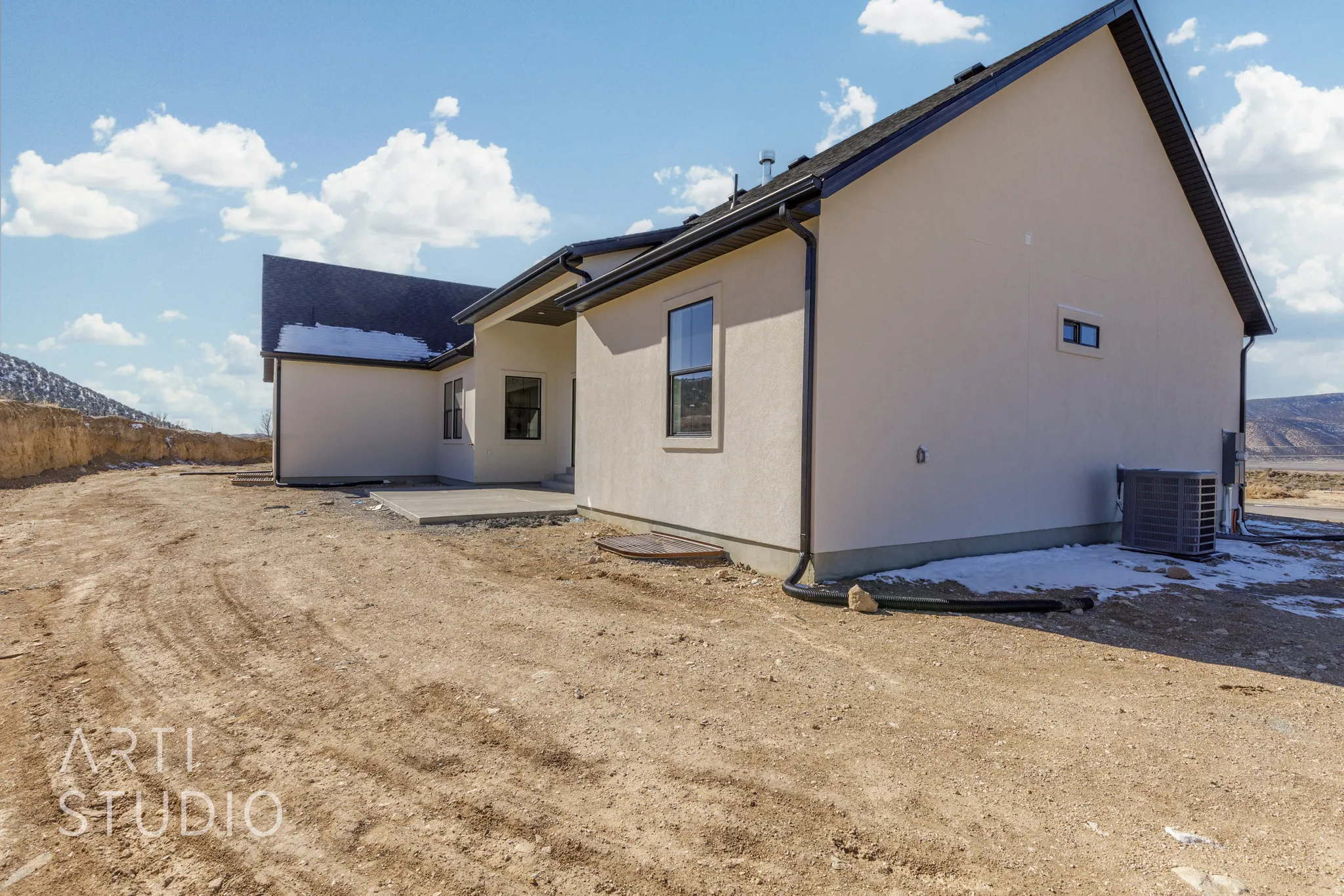 Back of property featuring a mountain view, a patio, and stucco siding