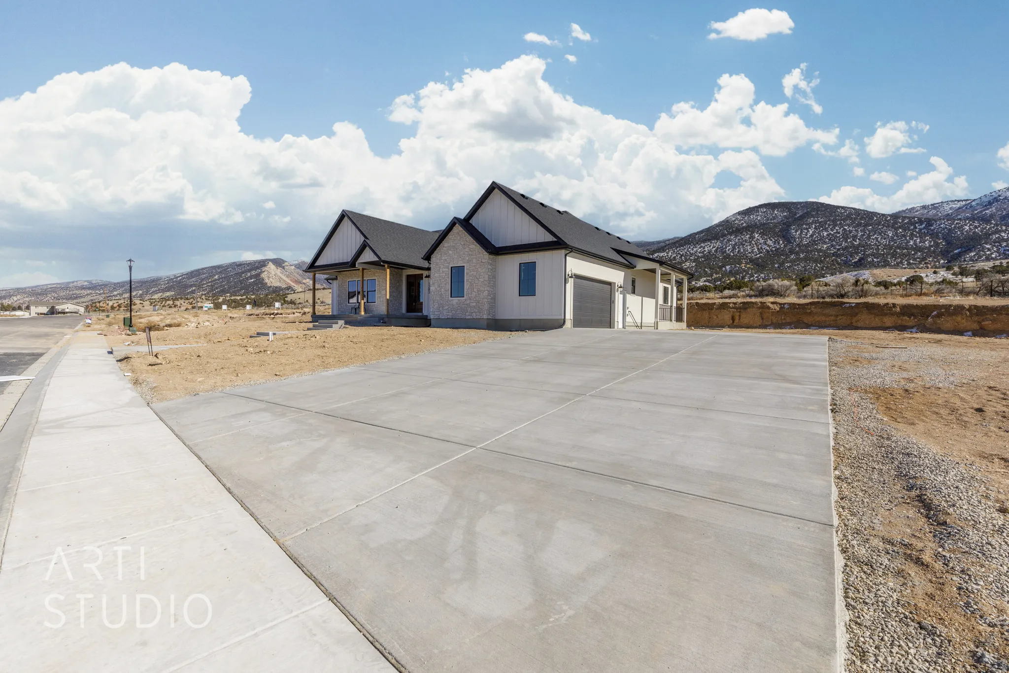 Modern inspired farmhouse featuring a mountain view, a porch, driveway, and a garage