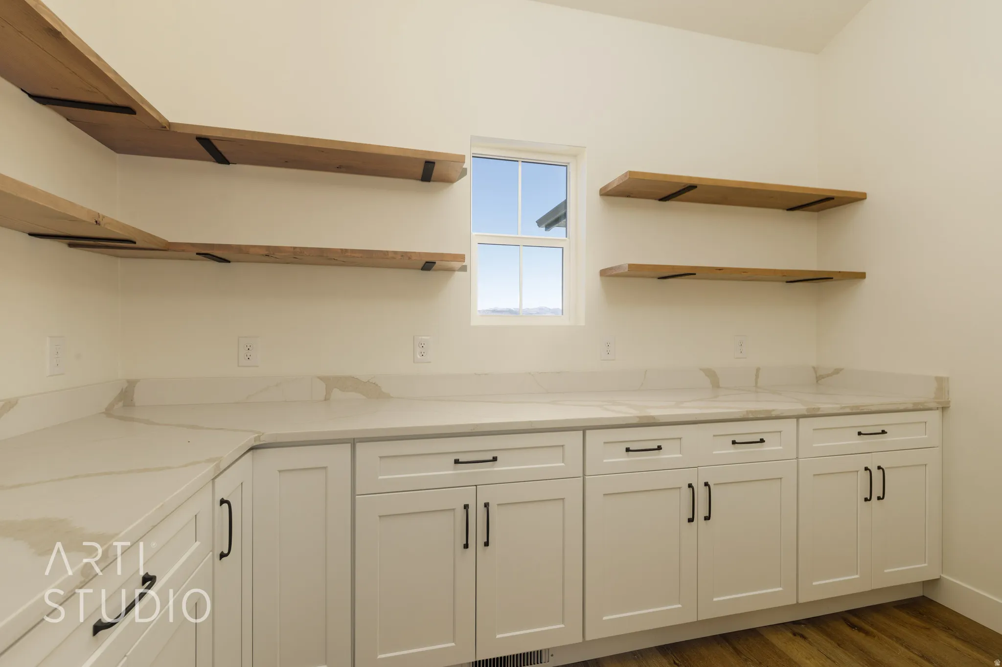 Kitchen featuring white cabinetry, light stone counters, dark wood-style floors, and open shelves