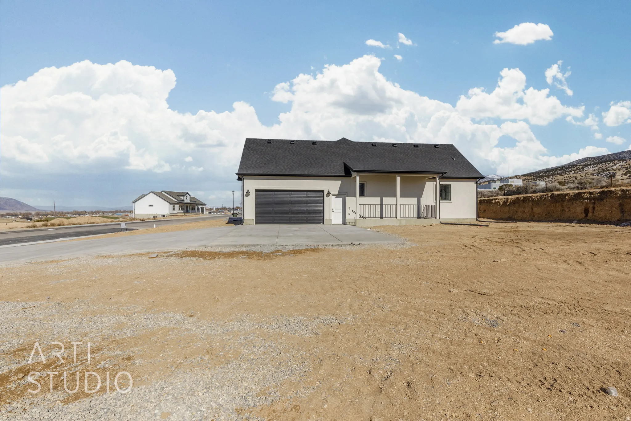 Rear view of property featuring concrete driveway, a garage, roof with shingles, and stucco siding