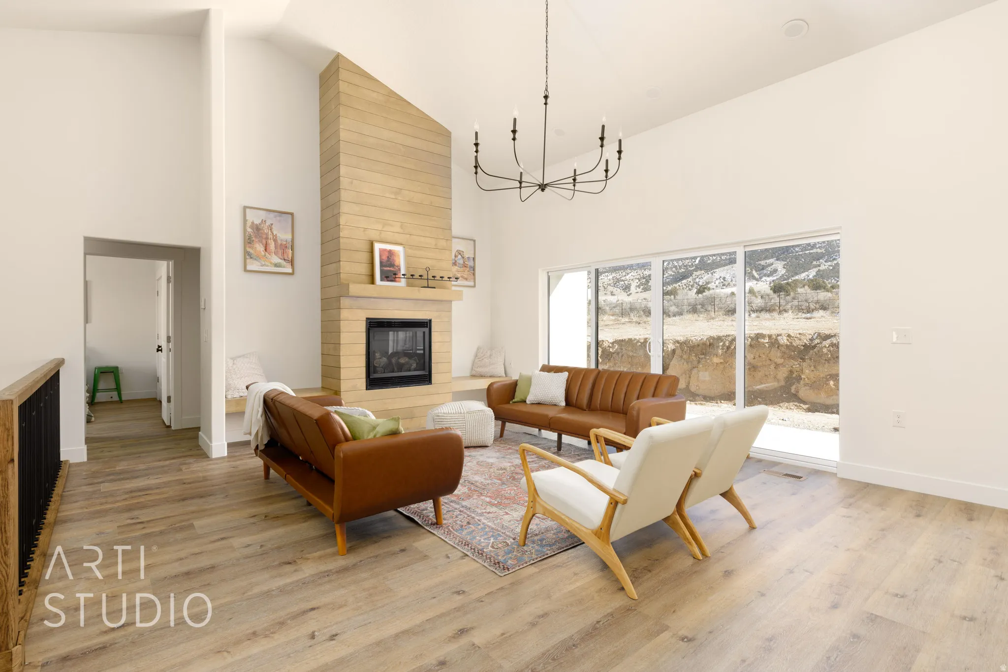 Living room with vaulted ceiling, a chandelier, light wood finished floors, and a fireplace