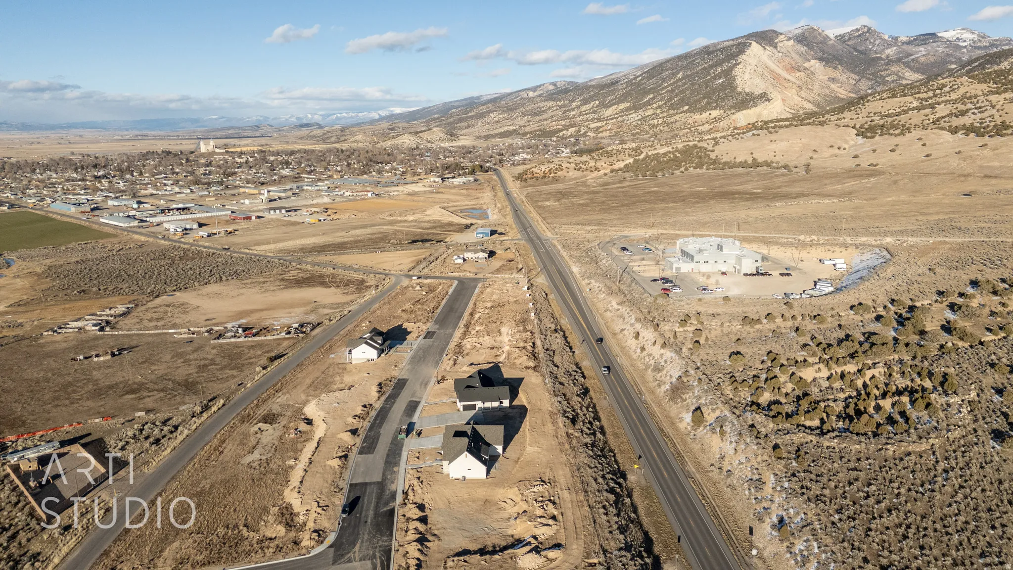 Aerial view of property's location featuring a mountainous background and rural landscape