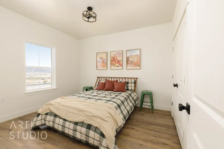 Bedroom with wood finished floors and a closet