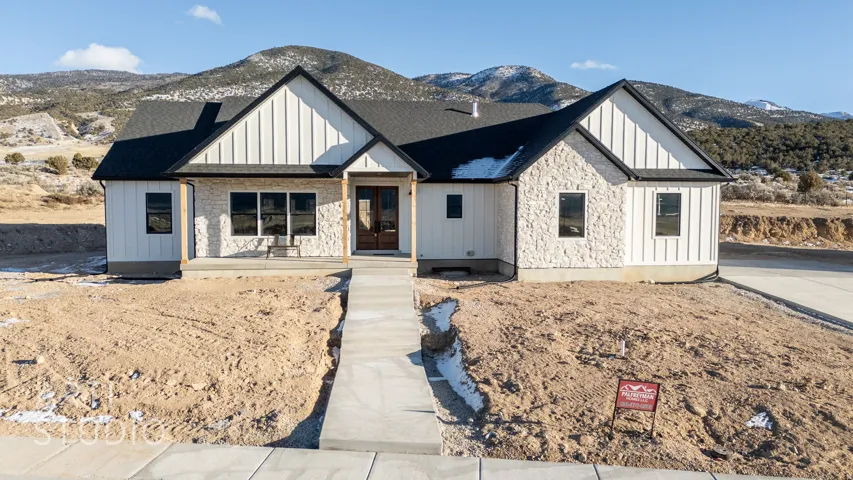 Modern farmhouse style home featuring a porch, board and batten siding, a mountain view, and roof with shingles