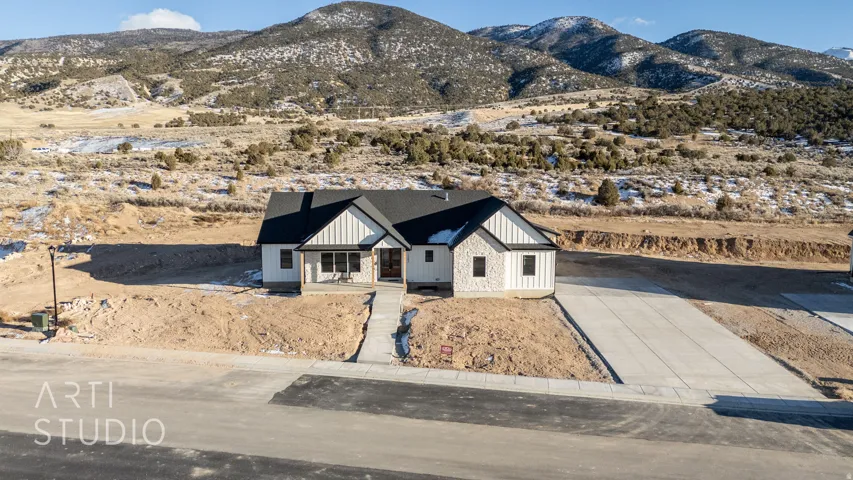 Modern farmhouse with board and batten siding, a mountain view, covered porch, and driveway