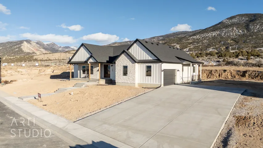 Modern inspired farmhouse with a mountain view, covered porch, board and batten siding, a garage, and concrete driveway