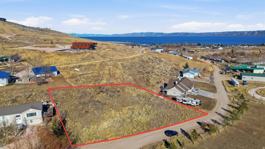 Aerial view of residential area with a mountainous background and property boundaries highlighted