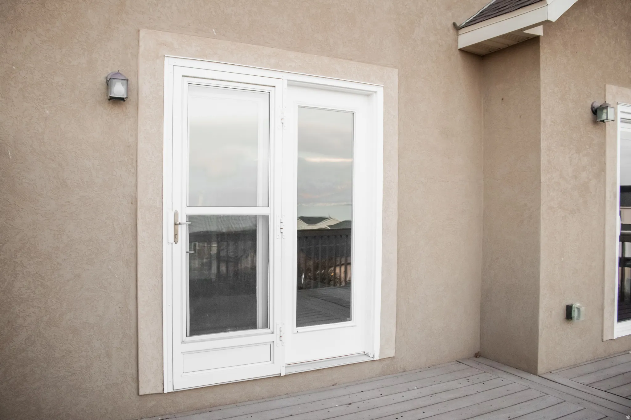 Doorway to property with stucco siding and a deck