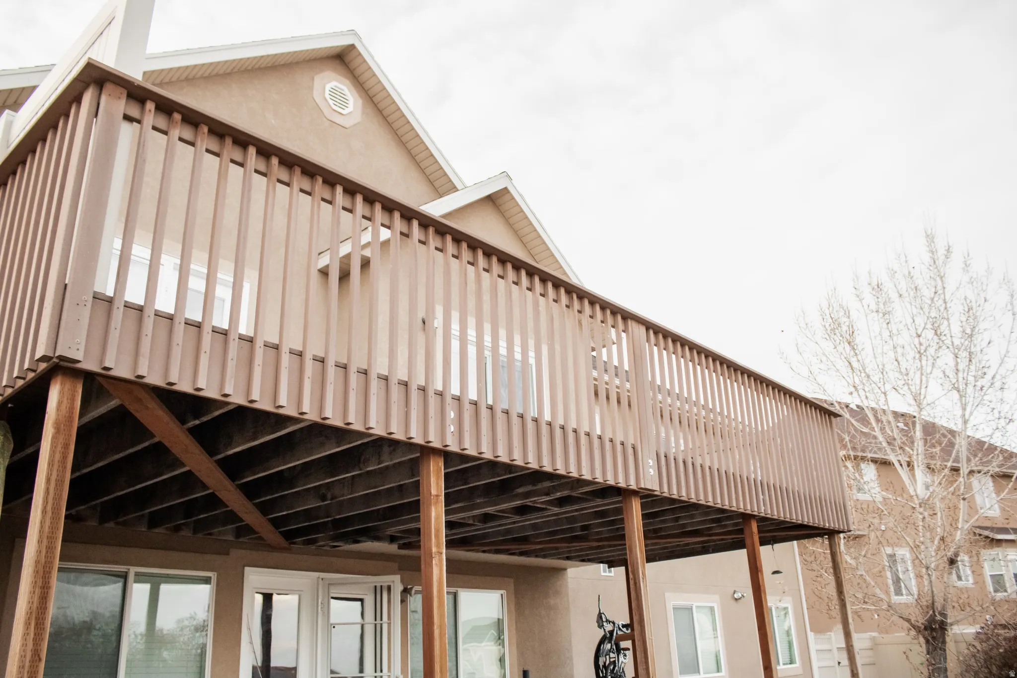View of property exterior with stucco siding and large deck