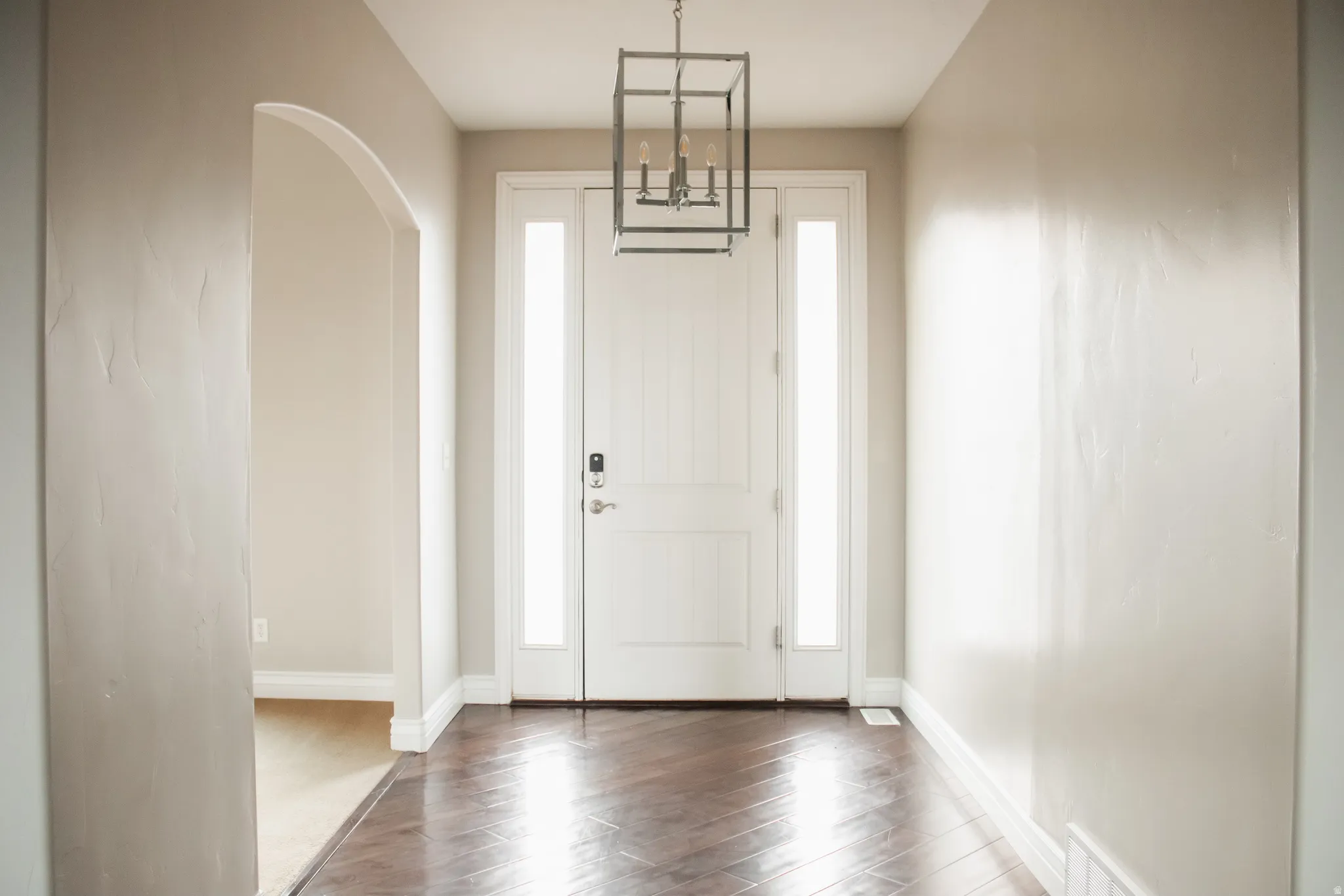 Foyer featuring wood finished floors and arched walkways
