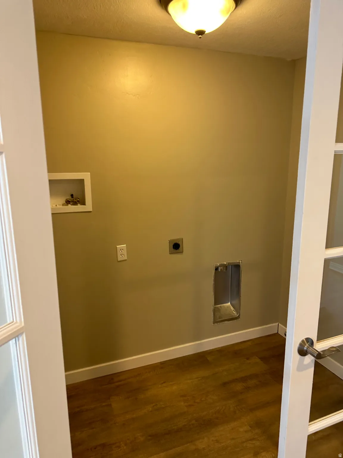 Laundry room featuring dark wood-style floors, hookup for a washing machine, a textured ceiling, and electric dryer hookup