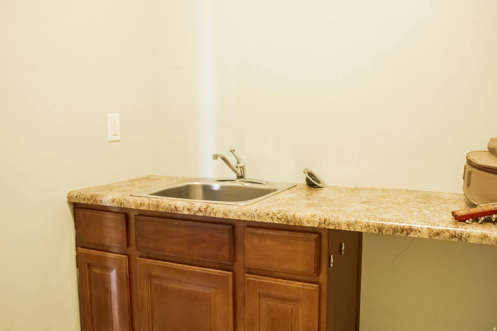 Laundry room with brown cabinets and a sink