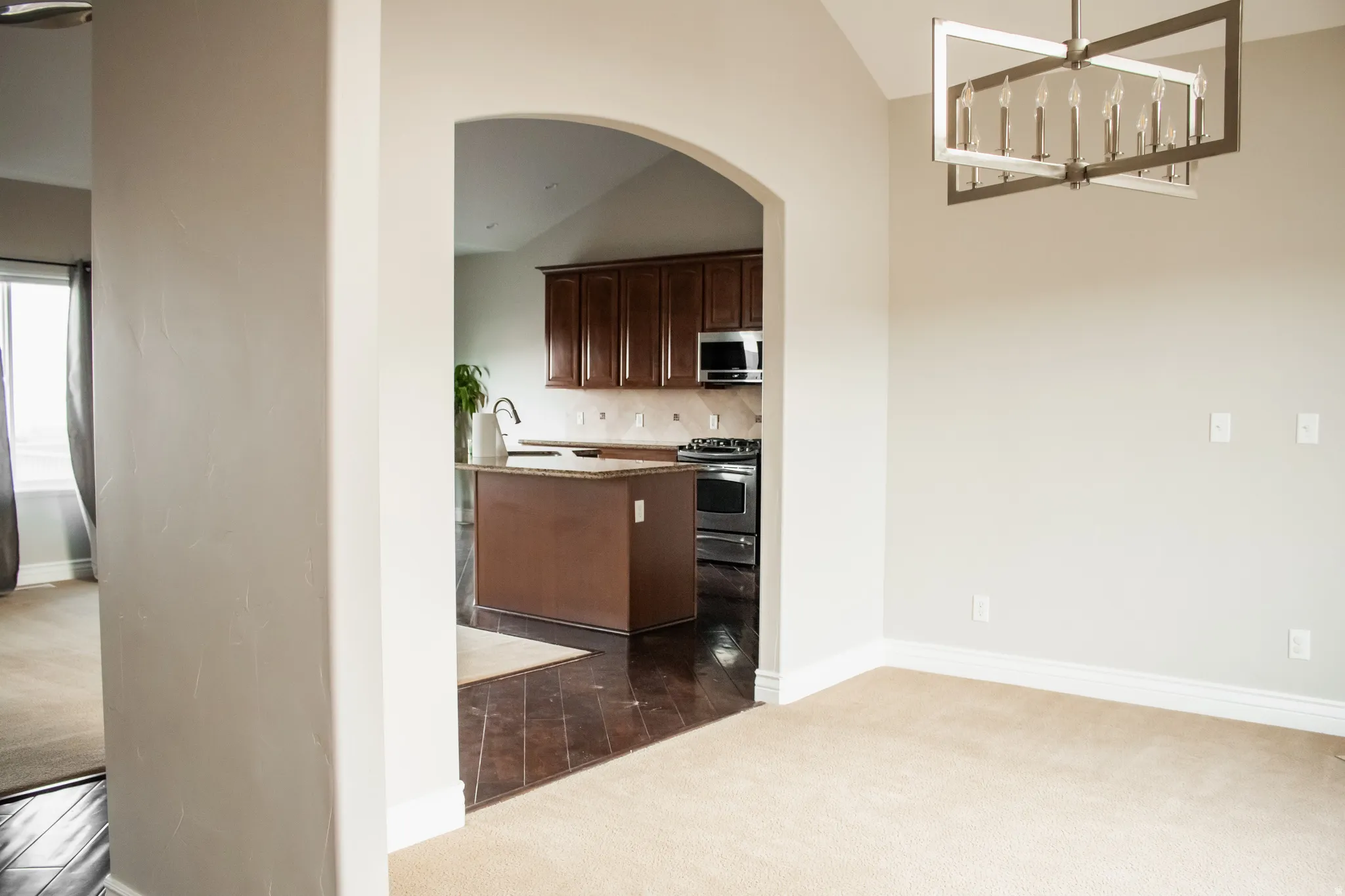 Open dining area featuring arched walkways, hanging light fixture and a fireplace.
