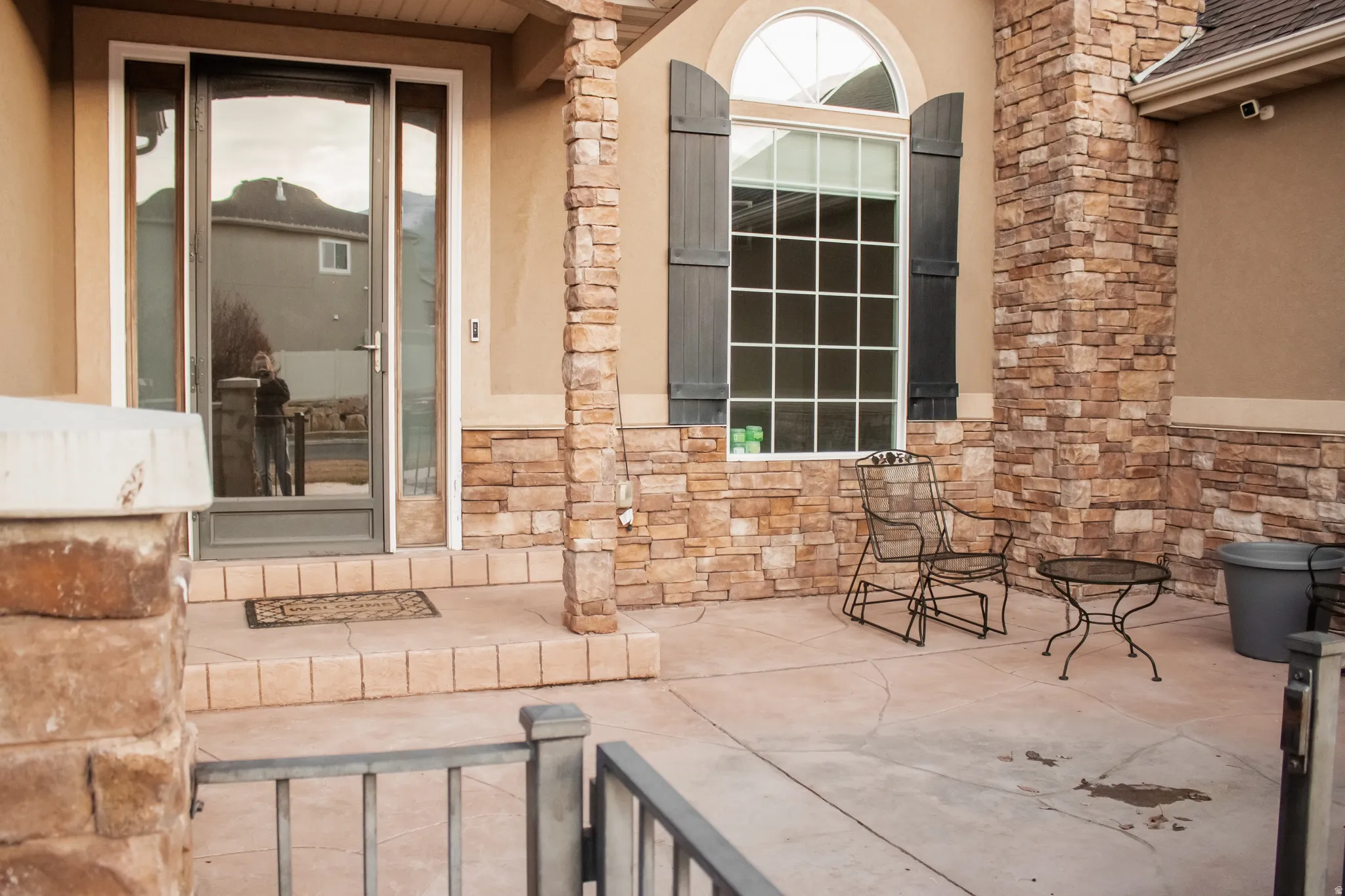 Property entrance with stone siding and stucco siding