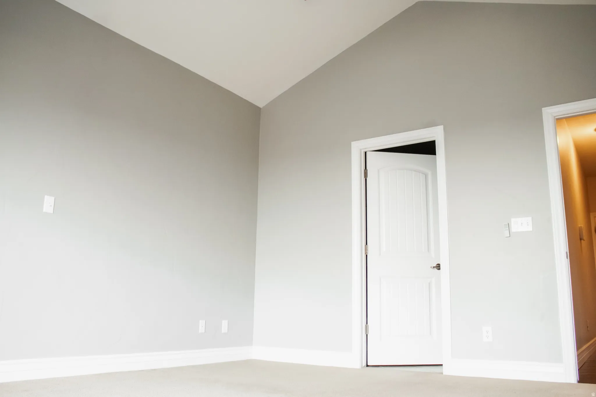 Master bedroom featuring vaulted ceiling, light carpet, and a ceiling fan