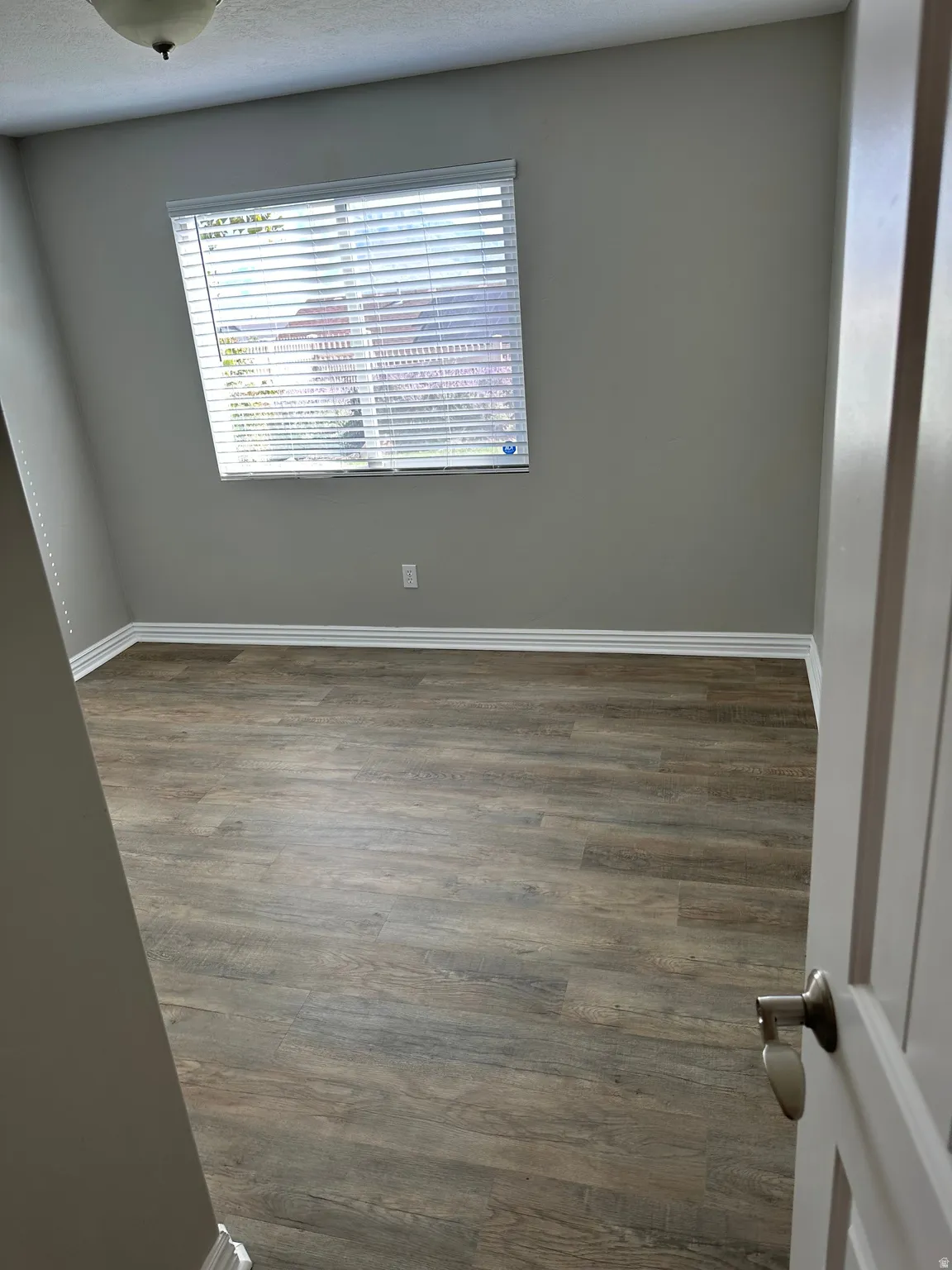 Spare room with baseboards and dark wood-style floors
